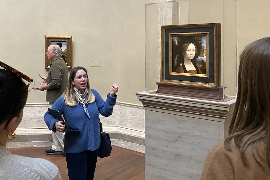 A woman gives a tour of the National Gallery of Art, standing beside the only Da Vinci painting in the Americas. 