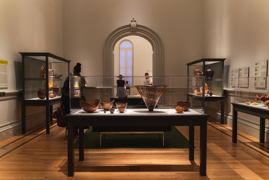 Visitors explore an exhibit of handcrafted bowls and vessels inside the Renwick Gallery.