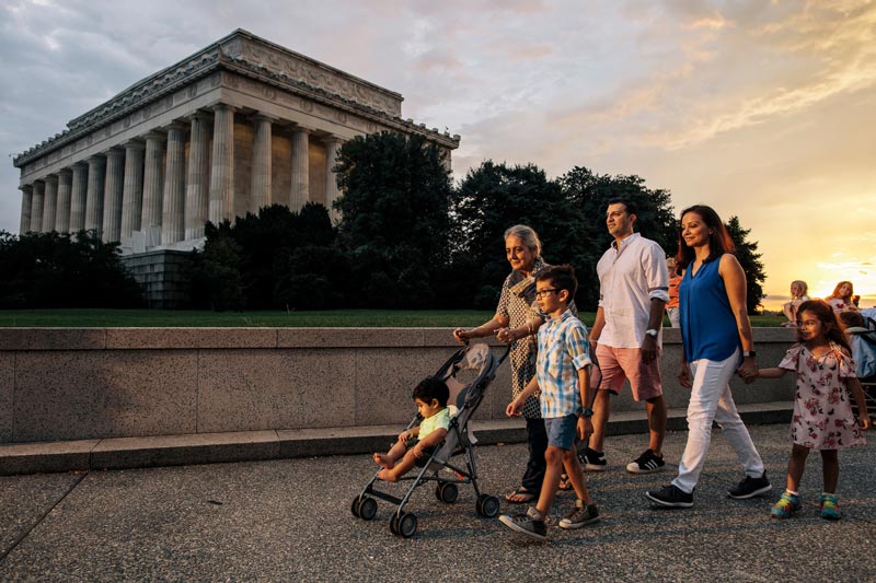 Family walking on the National Mall in front of the Lincoln Memorial during a summer evening in Washington, DC