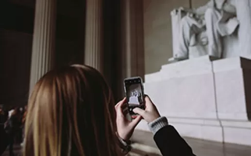 Girl taking photo of Lincoln Memorial
