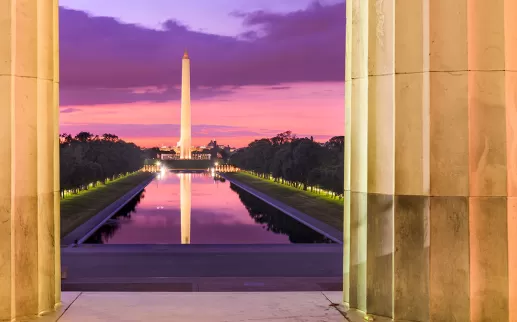 view of the Washington Monument and Reflecting Pool from the Lincoln Memorial with pretty sunset colors
