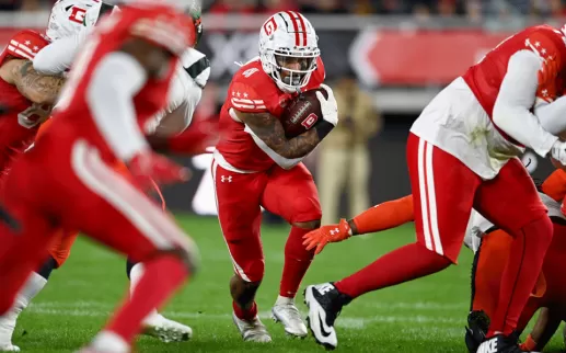 Football player running through people with the football
