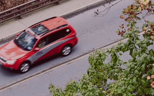 red taxi car driving on the road
