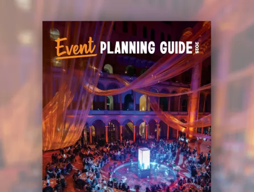 Cover of the 2025 Event Planning Guide, showing a colorfully-lit event in a historic building. 