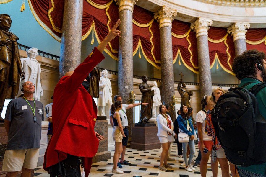 A guide gestures to statues while leading a tour through the National Statuary Hall inside the U.S. Capitol.