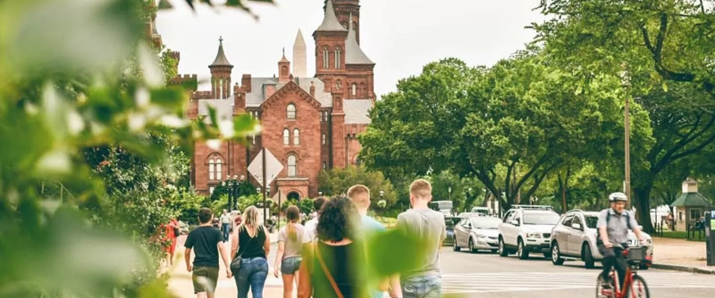 Visitors walking by the Smithsonian Castle on the National Mall in Washington, DC