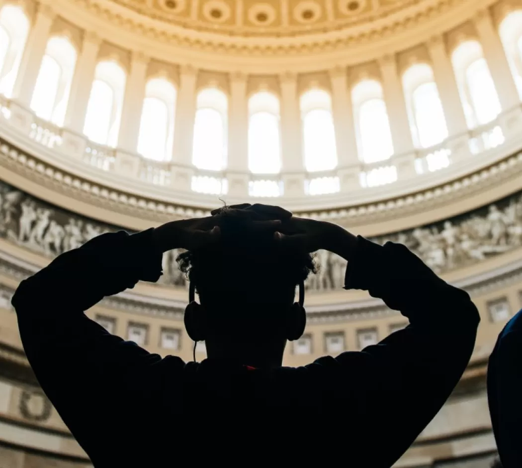 Students silhouetted looking up at the US Capitol Dome